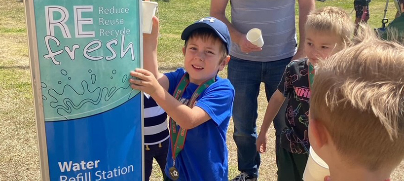 Young boy enjoying a drink from the water refill station