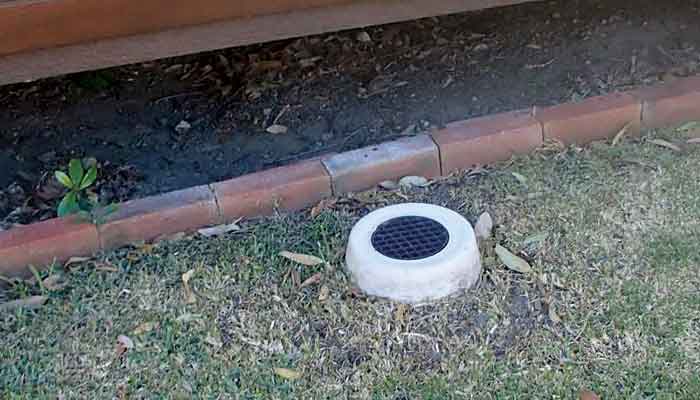 image of circular concrete pipe opening with a loose fitting grate